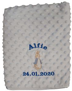 a white blanket with blue lettering on it and a bunny in the corner that says,'afie '