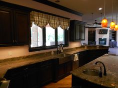 a kitchen with granite counter tops and black cabinets