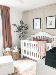 a baby's room with a white crib, pink and black decor and pictures on the wall