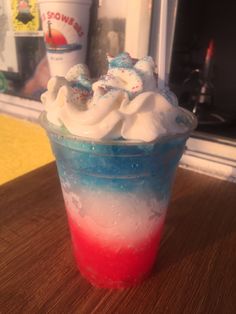 an ice cream sundae with red, white and blue icing in a plastic cup