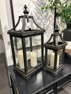 two lanterns sitting on top of a table