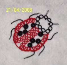 two black and red beads on a white cloth with the words 2 / 0 / 4 / 2006