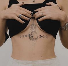 a woman's stomach with the moon and phases tattooed on it