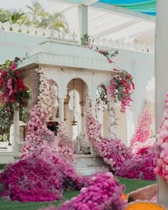 a white gazebo surrounded by pink and purple flowers