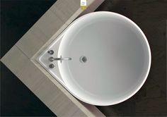 a white sink sitting on top of a tiled floor