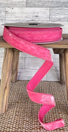 a pink ribbon sitting on top of a wooden bench