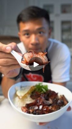 a man is holding a spoon over a bowl of food with meat and vegetables in it