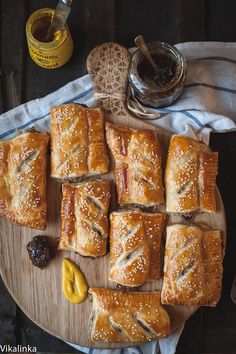 breads with sesame seeds and jelly on a cutting board