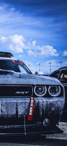 the front end of a black and white car with red lettering on it's hood