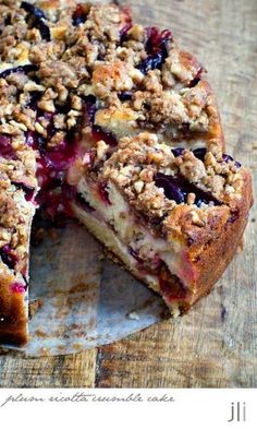 a close up of a pie on a wooden table with one slice missing from it