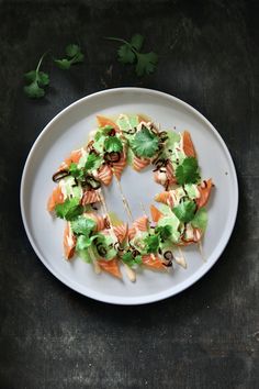 a white plate topped with lots of food on top of a wooden table next to cilantro