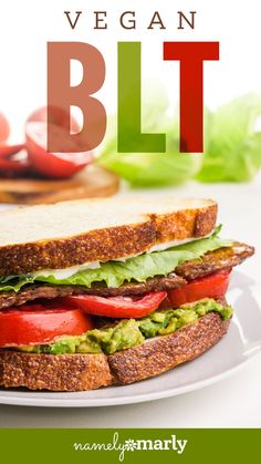 the vegan blt sandwich on a white plate with lettuce and tomatoes