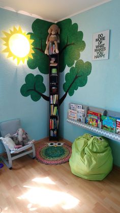 a child's room decorated in blue and green with a tree painted on the wall