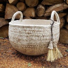 a large white basket sitting on top of a pile of wood