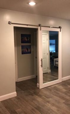 an empty living room with wood floors and white doors