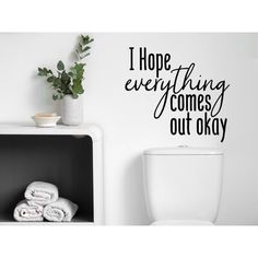 a white toilet sitting in a bathroom next to a black and white wall decal