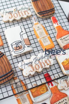 decorated cookies are on a cooling rack with wine bottles and other items in the background