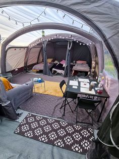 the inside of a tent with tables, chairs and couches in it is shown