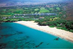 an aerial view of a beach and resort from the air, with trees surrounding it