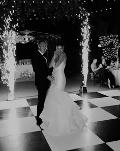 a bride and groom dancing on the dance floor at their wedding reception in black and white