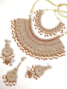 A semi-Indian bridal set is a stunning and elegant jewelry ensemble that beautifully combines elements of traditional Indian craftsmanship with modern design sensibilities. This exquisite set is designed for brides who wish to strike a perfect balance between traditional and contemporary aesthetics on their special day. The semi-Indian bridal set typically includes a harmonious combination of statement necklaces, earrings, tikka, and jummar all carefully crafted with intricate detailing and luxurious materials. These pieces enhance the bride's beauty and complement her wedding attire, whether a saree, lehenga or any other traditional outfit. One of the key features of this bridal set is its versatility. It effortlessly melds the opulence of Indian jewelry with more understated, modern elem Saree Lehenga, Traditional Outfit, Statement Necklaces, Bride Style, Traditional Indian, Bridal Set, Indian Bridal, Wedding Attire, Elegant Jewelry