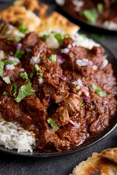 a plate full of food with rice and meat on it, next to some pita bread