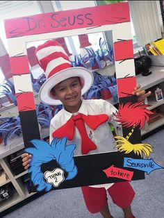 a child holding up a sign with the cat in the hat on it