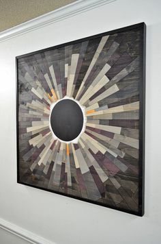 an art piece is hanging on the wall in front of a door with a black and white circle