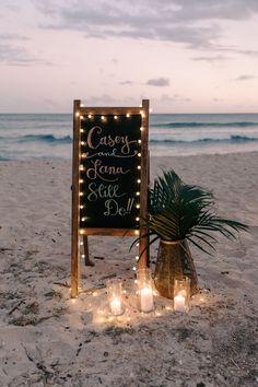 a sign that is on the sand with candles