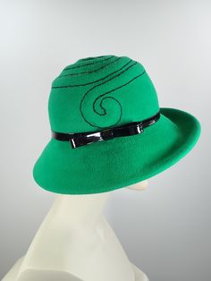 This pretty Kelly green medium brim hat is hand blocked over a vintage hat block and hand sewn. The asymmetrical brim rolls upward in the front and on the left side. Millinery wire is sewed inside of the brim edge to help the hat keep it's shape. The band is a gorgeous vintage patent leather with a matching bow. The top of the hat is hand embroidered in a swirl pattern in black cotton floss. An inner grosgrain headband helps avoid damage from makeup. Gorgeous in every way!+++++++++++++++++++++++ Green Hat Bands For Kentucky Derby, Adjustable Green Fedora Felt Hat, Adjustable Wide Brim Green Felt Hat, Green Fedora Felt Hat For Spring, Spring Fitted Green Fedora, Green Adjustable Felt Hat For Kentucky Derby, Fitted Green Brimmed Fedora, Green Winter Fedora Felt Hat, Fitted Green Fedora For Kentucky Derby