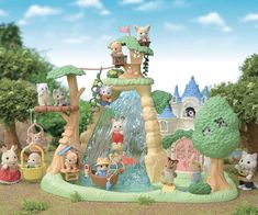 a group of toy animals playing in a water fountain with trees and buildings behind them