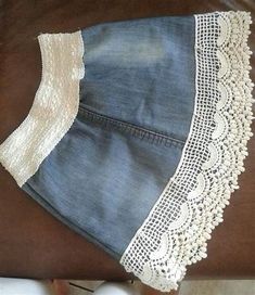 a pair of jeans with white lace on them sitting on top of a brown horse