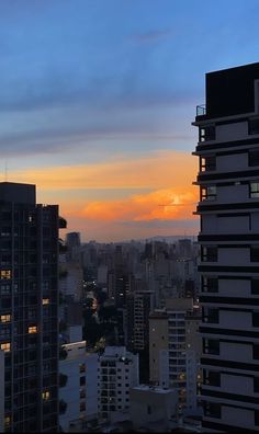 the sun is setting over some tall buildings in this cityscape, as seen from an apartment building