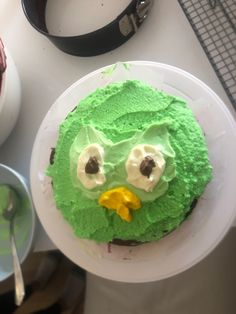 a cake with green frosting and an angry bird face