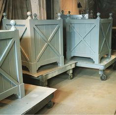 three wooden planters sitting on top of dollys in a room filled with wood