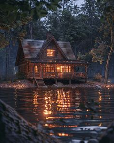 a cabin is lit up at night on the water