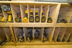 a wooden shelf filled with lots of different types of drillers and other tools on top of it