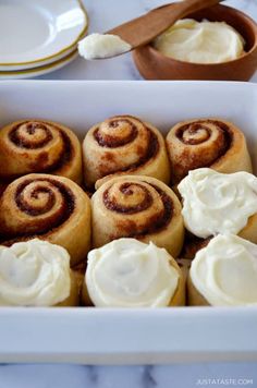 some cinnamon rolls in a white dish on a table