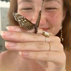 a woman holding a butterfly on her finger