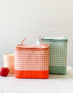 two baskets sitting on top of a table next to an apple