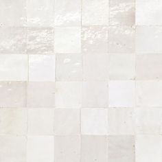 a white tiled wall with small squares on it