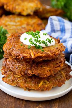 stack of potato pancakes with sour cream on top and parsley in the middle, ready to be eaten