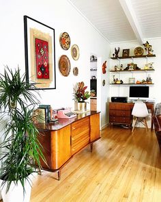 a living room filled with furniture and a potted plant on top of a wooden table