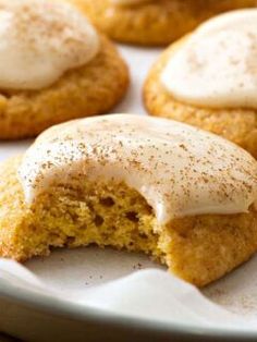 some cookies with frosting on top are sitting on a plate