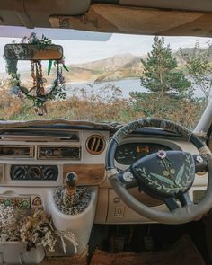 the interior of an old car is decorated with flowers and greenery as well as steering wheel controls