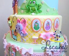 there is a cake decorated with cartoon characters on the top and bottom tier, as well as an image of a frog