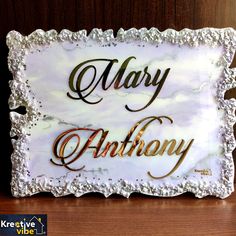 a sign that says mary and anthony on the side of a table with a wooden background