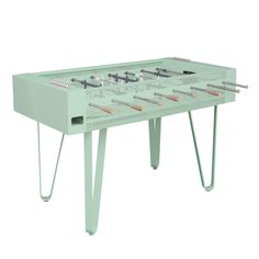 a green table that has some tools on it and is in the shape of a foosball