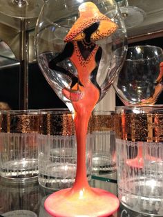 a table topped with glasses and vases filled with different types of glassware in front of a mirror