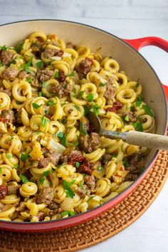 a skillet filled with pasta and meat